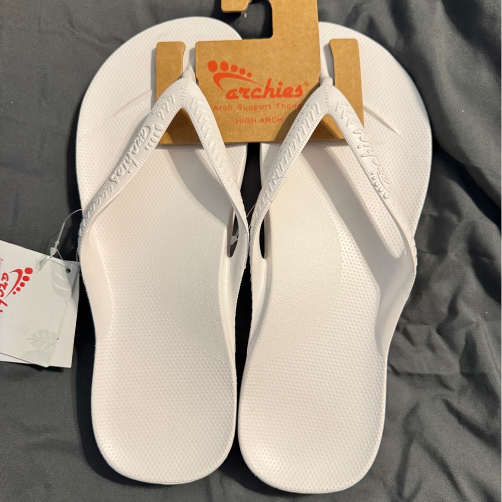 Brand new. Never worn. White Archie’s flip flops. Men’s size 12